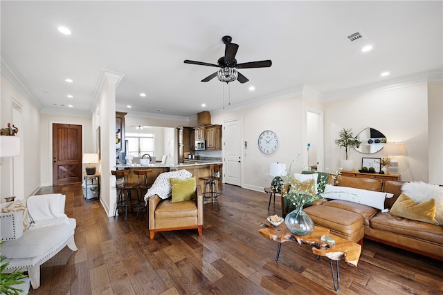 living room featuring ceiling fan, ornamental molding, and dark hardwood / wood-style floors