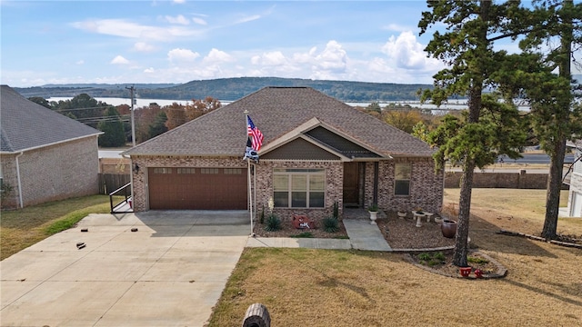 view of front facade with a mountain view, a front yard, and a garage