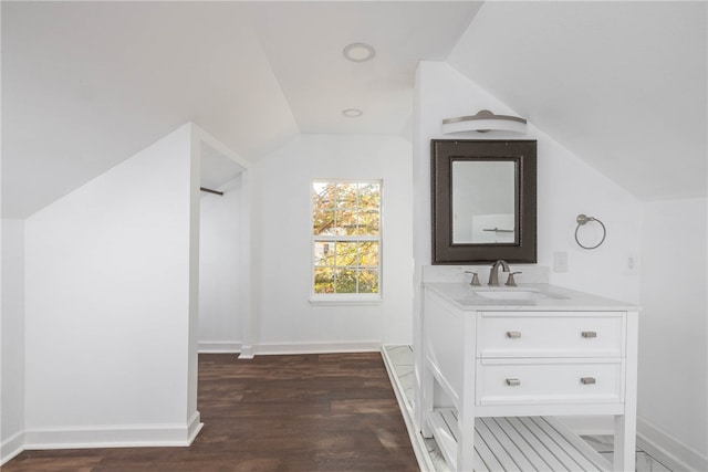 bathroom featuring vanity, wood-type flooring, and lofted ceiling