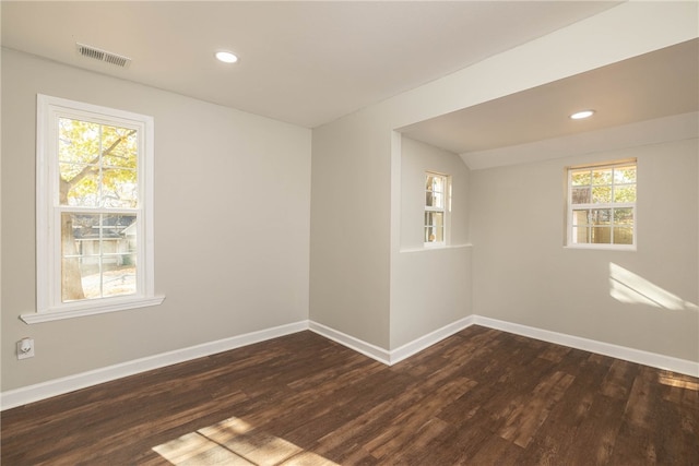 empty room with a healthy amount of sunlight and dark wood-type flooring