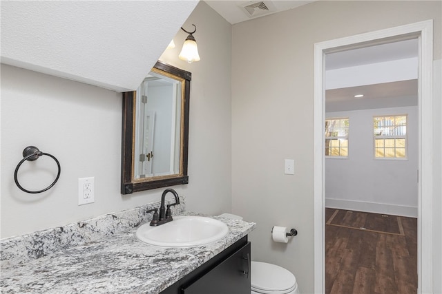 bathroom with vanity, hardwood / wood-style floors, and toilet