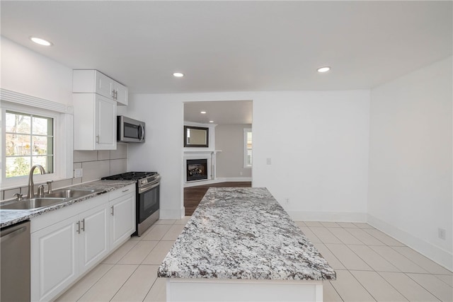 kitchen with a center island, sink, appliances with stainless steel finishes, and white cabinetry