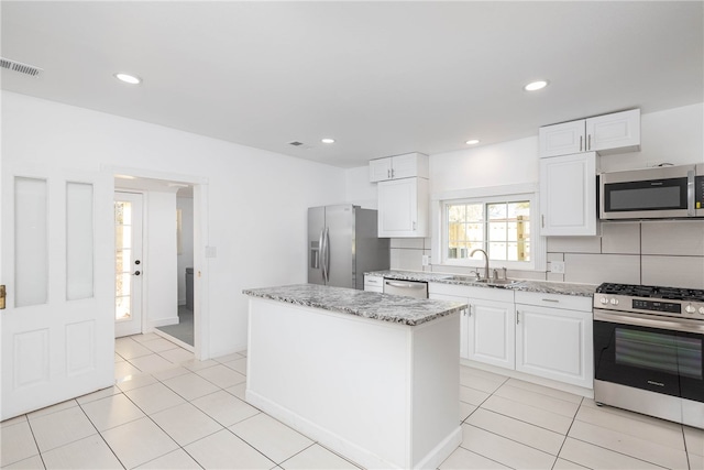 kitchen featuring sink, appliances with stainless steel finishes, a center island, and white cabinets