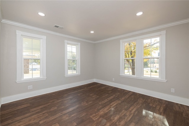 empty room with crown molding, dark hardwood / wood-style floors, and plenty of natural light