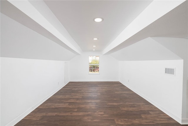 bonus room with dark wood-type flooring and lofted ceiling