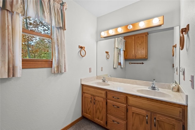 bathroom featuring double vanity, a sink, and baseboards