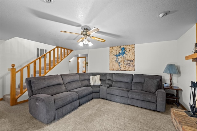 carpeted living area featuring ceiling fan, stairs, and a textured ceiling