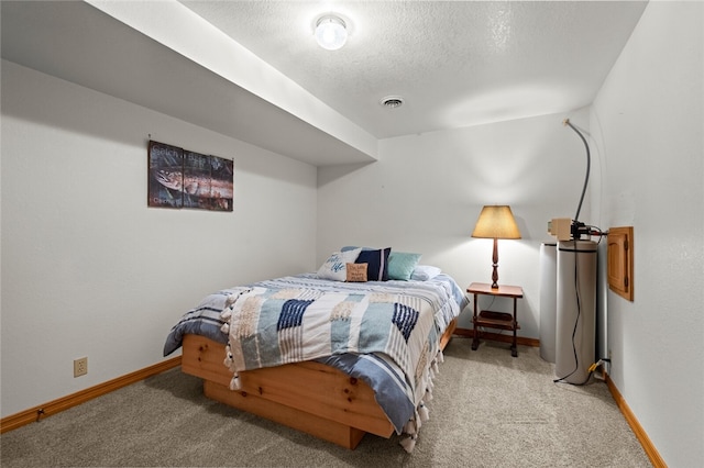 bedroom featuring a textured ceiling, baseboards, visible vents, and light colored carpet