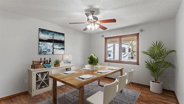 dining space with ceiling fan, dark hardwood / wood-style flooring, and a textured ceiling