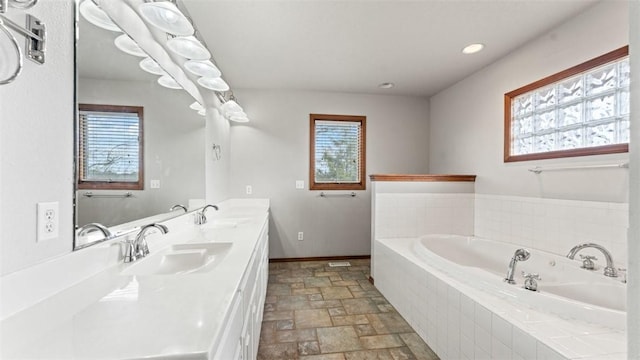 bathroom with vanity and a relaxing tiled tub