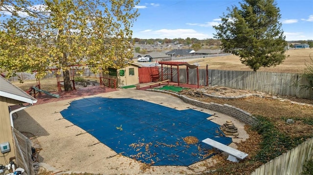 view of swimming pool with a diving board and a patio