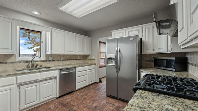 kitchen featuring sink, appliances with stainless steel finishes, white cabinetry, extractor fan, and light stone countertops