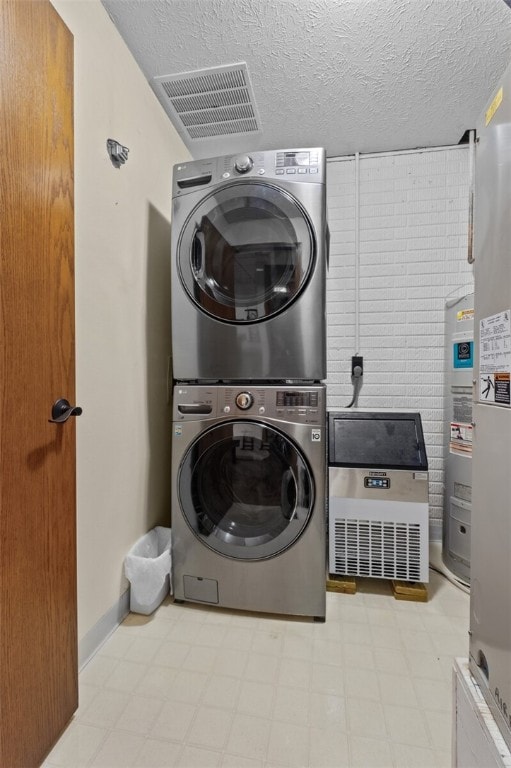 laundry room with a textured ceiling, laundry area, visible vents, stacked washer / drying machine, and light floors