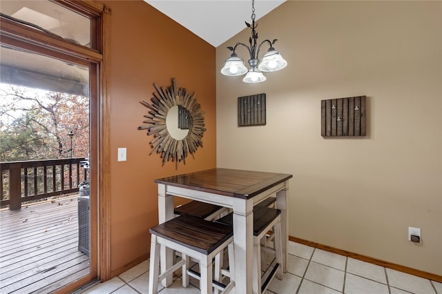 dining space featuring a chandelier, vaulted ceiling, baseboards, and light tile patterned floors