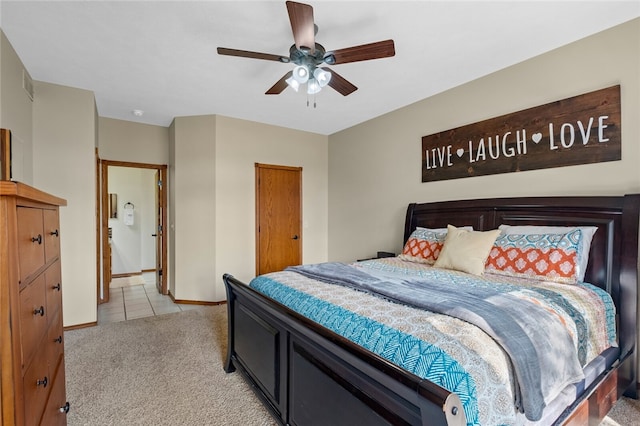 bedroom with light carpet, baseboards, a ceiling fan, and light tile patterned flooring