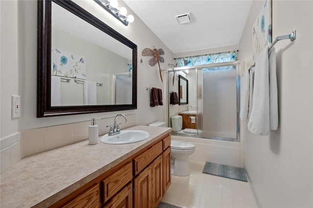 bathroom with toilet, visible vents, combined bath / shower with glass door, and vanity