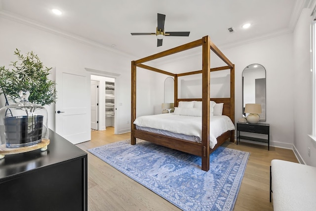 bedroom with ornamental molding, ceiling fan, and light hardwood / wood-style flooring