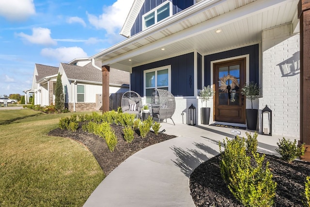 property entrance with a yard and covered porch