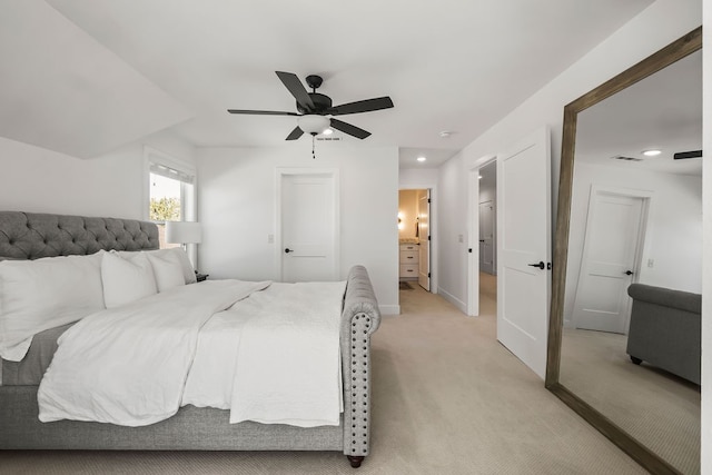 bedroom featuring ensuite bathroom, light carpet, and ceiling fan