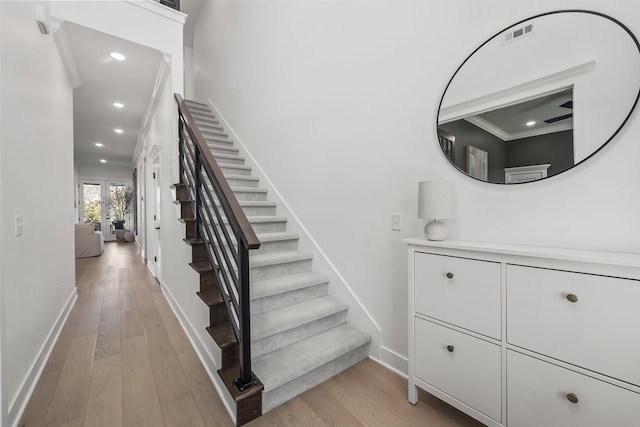 stairway featuring hardwood / wood-style floors, crown molding, and french doors