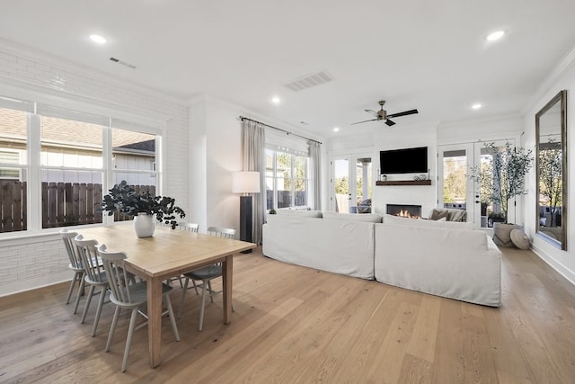 dining space featuring ornamental molding, ceiling fan, light hardwood / wood-style floors, and french doors