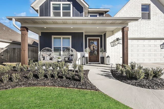 view of exterior entry featuring a garage and covered porch