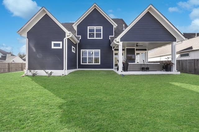 back of property featuring ceiling fan, outdoor lounge area, a patio area, and a lawn