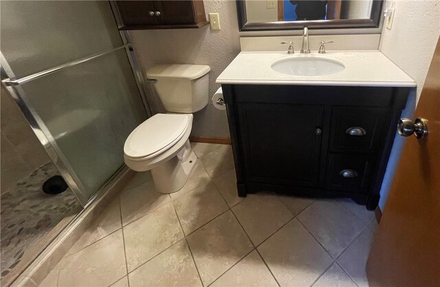 bathroom featuring vanity, toilet, tile patterned flooring, and a shower with door