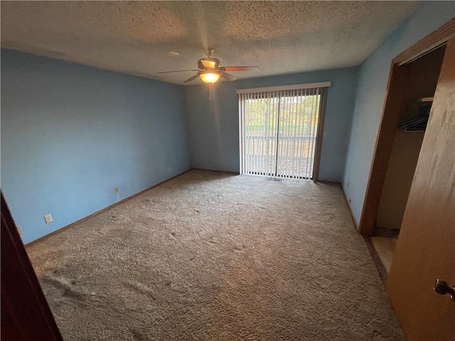 carpeted spare room with a textured ceiling and ceiling fan