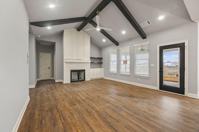 unfurnished living room featuring vaulted ceiling with beams, a wealth of natural light, and hardwood / wood-style floors