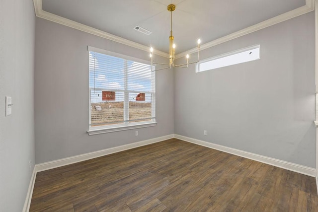 spare room featuring dark wood-type flooring, ornamental molding, and an inviting chandelier