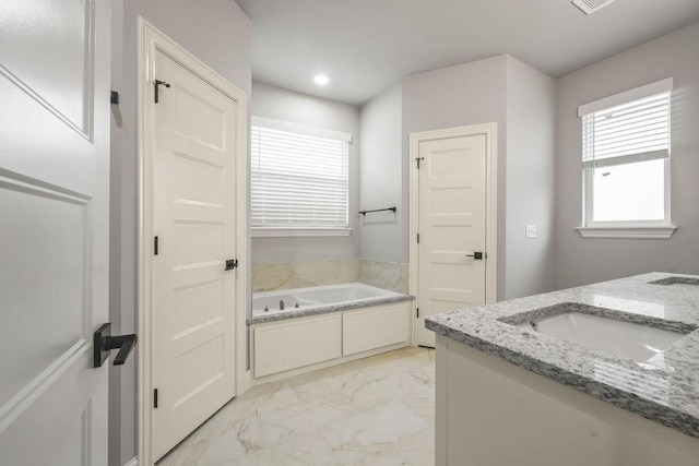 bathroom featuring vanity and a tub