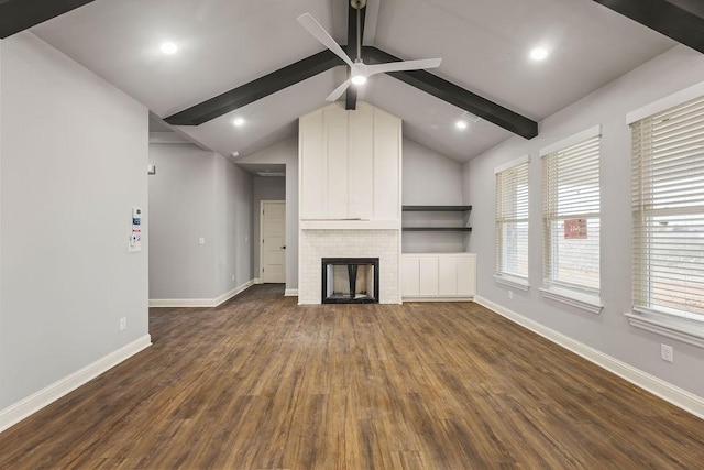 unfurnished living room featuring dark hardwood / wood-style floors, ceiling fan, a fireplace, and vaulted ceiling with beams