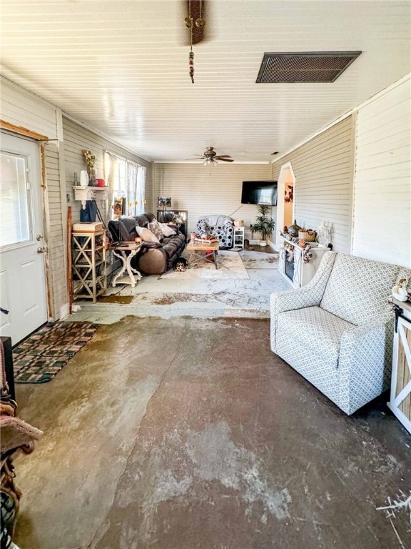 living room featuring ceiling fan and concrete flooring