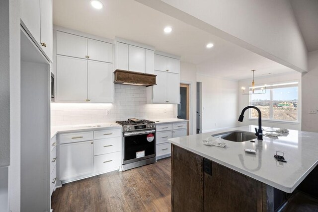 kitchen with dark wood-style flooring, a sink, white cabinets, stainless steel gas stove, and backsplash