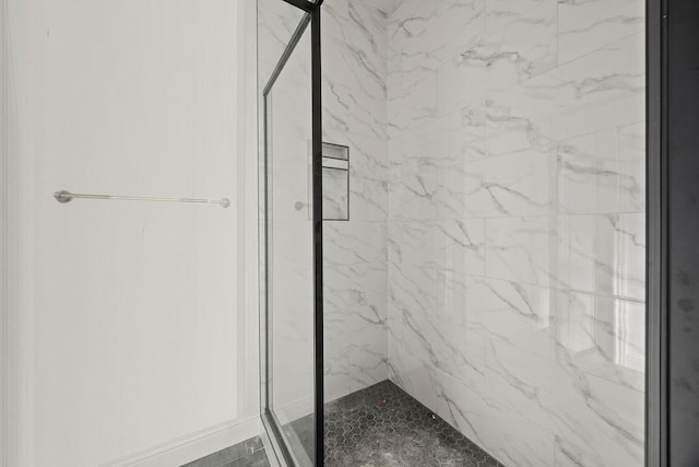 bathroom featuring a marble finish shower