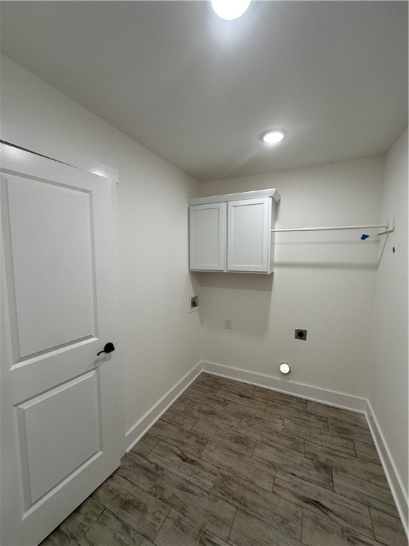 laundry area with electric dryer hookup and cabinets