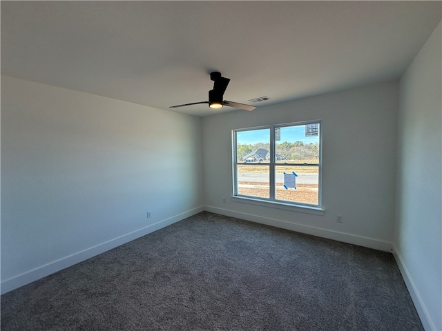 spare room with dark carpet and ceiling fan