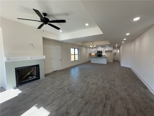 unfurnished living room featuring dark hardwood / wood-style floors and ceiling fan with notable chandelier