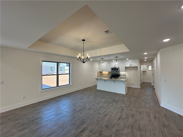 kitchen with white cabinetry, dark hardwood / wood-style flooring, pendant lighting, a kitchen island, and appliances with stainless steel finishes