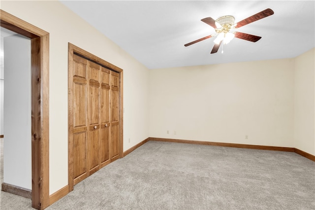 unfurnished bedroom with a closet, light colored carpet, and ceiling fan