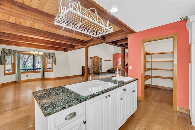 kitchen featuring beamed ceiling, wooden ceiling, pendant lighting, white electric cooktop, and white cabinets