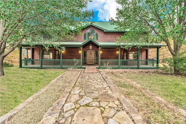 cabin with covered porch and a front lawn