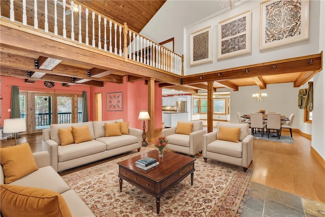 living room featuring beam ceiling, wooden ceiling, wood-type flooring, a high ceiling, and french doors