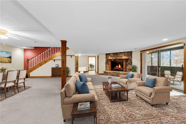 living room featuring a fireplace, carpet, and ceiling fan