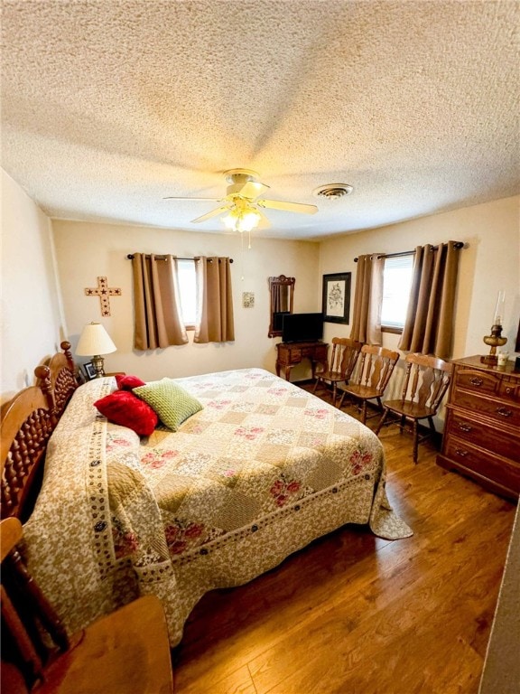 bedroom featuring a textured ceiling, hardwood / wood-style flooring, and ceiling fan