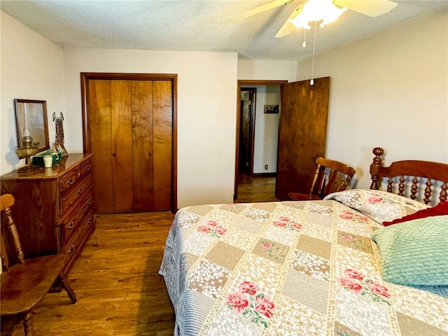 bedroom featuring a closet, dark hardwood / wood-style floors, a textured ceiling, and ceiling fan