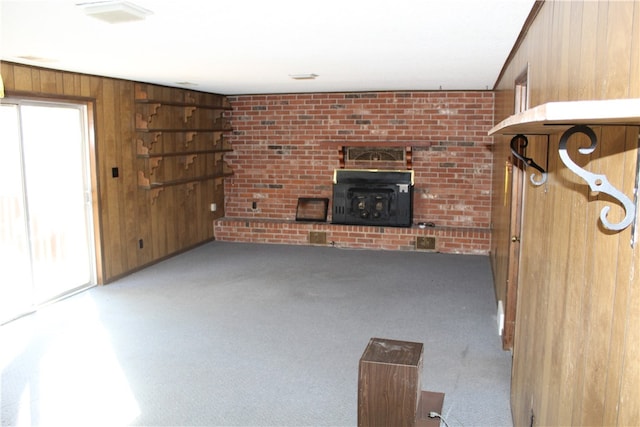 unfurnished living room featuring light carpet, wood walls, and a fireplace