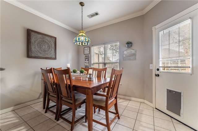 tiled dining room with ornamental molding and a healthy amount of sunlight