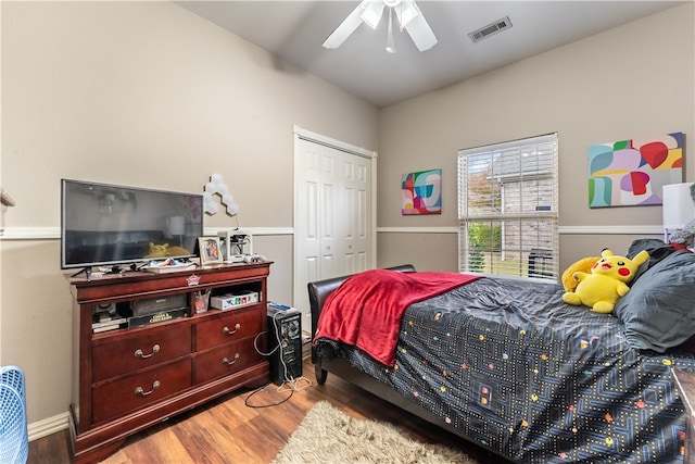 bedroom with a closet, hardwood / wood-style flooring, and ceiling fan